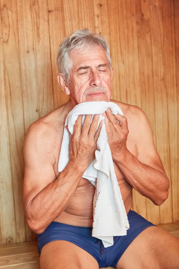 Man in blue underwear holding a white towel against a wooden background